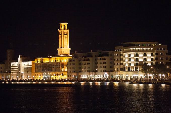 Il lungomare di Bari illuminato di notte con la torre