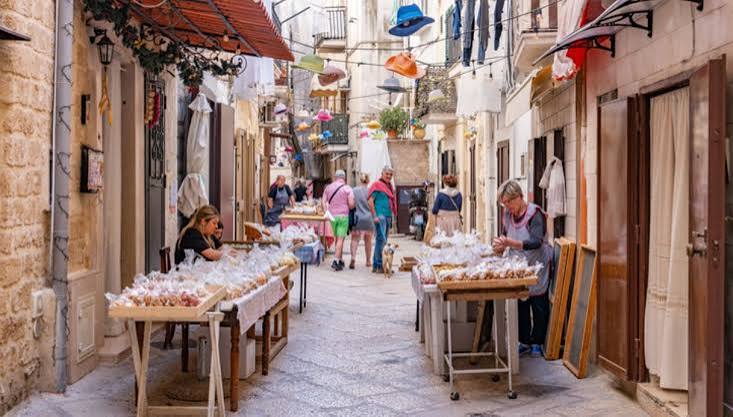 Stradina di Bari Vecchia con bancarelle di orecchiette e passanti