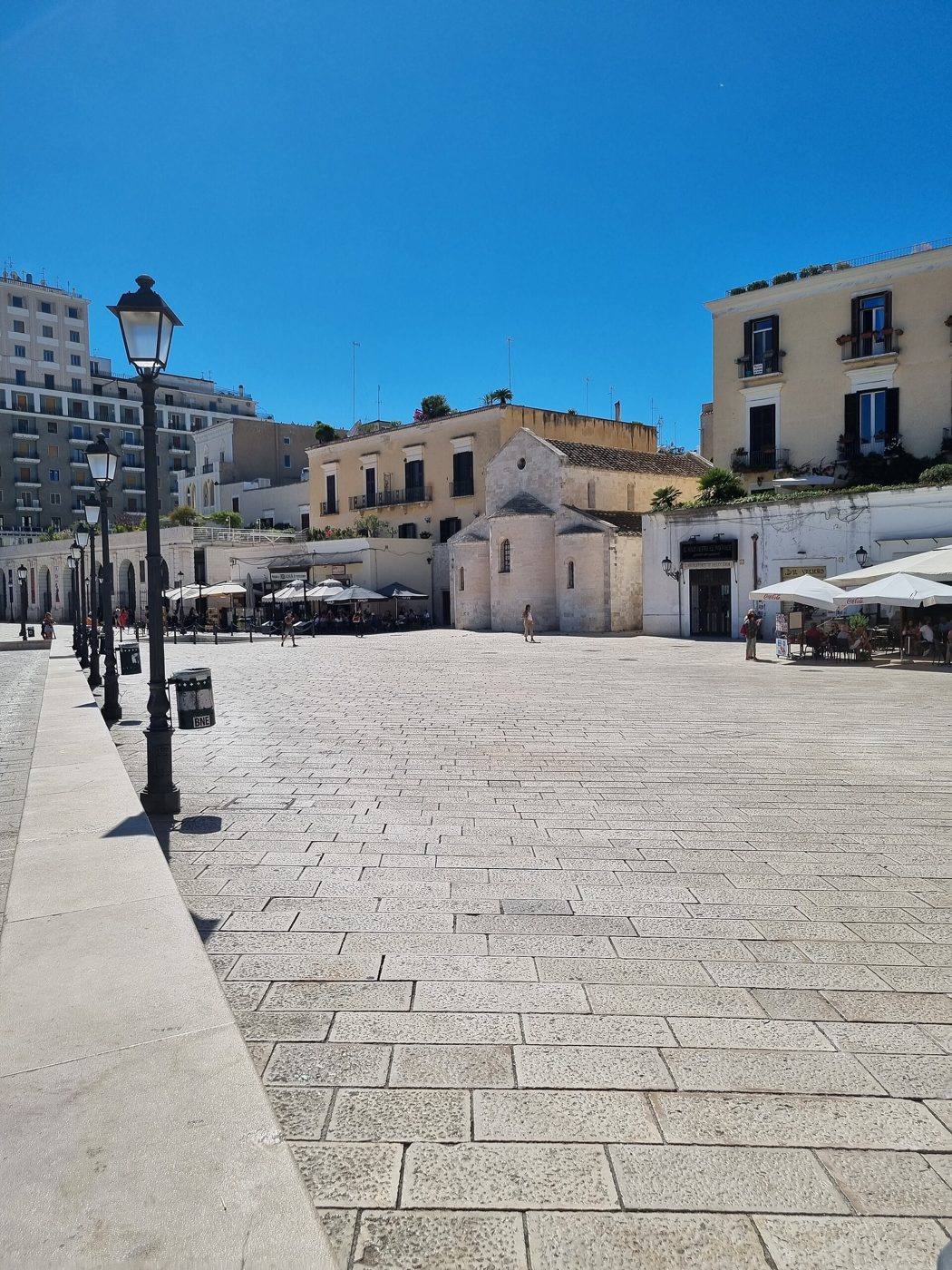 Locali e passanti in Piazza del Ferrarese a Bari