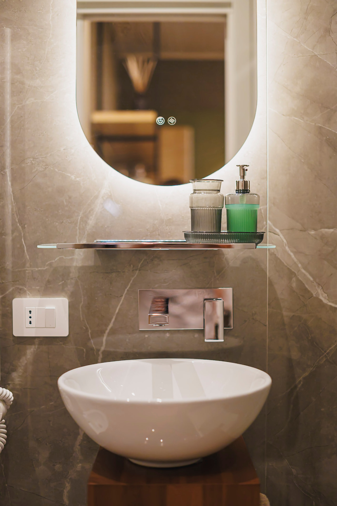 Lavabo con specchio retroilluminato e dettagli marmo del bagno di Casa Bolero 48