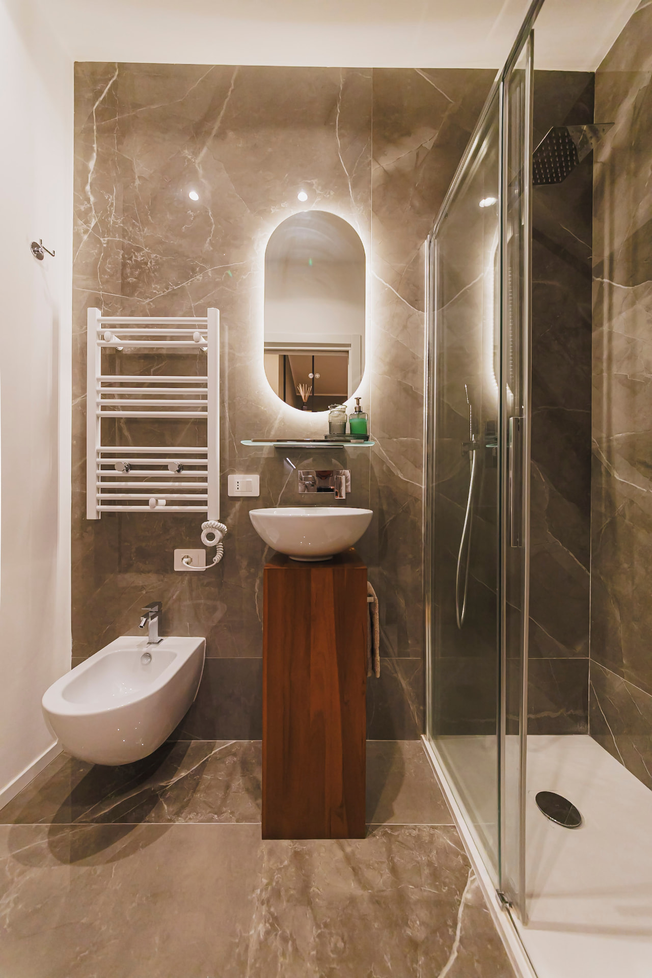 Bagno in marmo con lavabo su colonna legno e box doccia di Casa Bolero 48